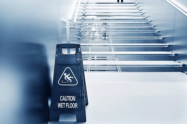 wet floor caution sign near the glass staircase.